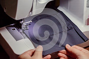 Woman hands using the sewing machine