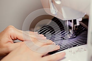Woman hands using the sewing machine