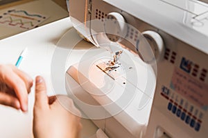 Woman hands using sewing machine