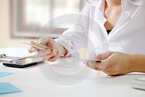 Woman hands using smartphone shopping online and credit card holding on.