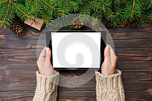 Woman hands using tablet computer on wooden table bachground. cristmas shopping time. Happy Christmas mock up background, top view