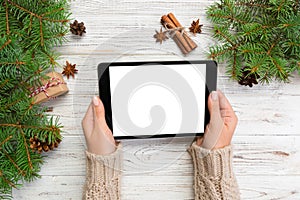 Woman hands using tablet computer on wooden table bachground. cristmas shopping time. Happy Christmas mock up background, top view