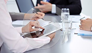 Woman hands using tablet at meeting. Business people group working together in office, close-up. Negotiation and