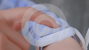 Woman hands using wearable white smart watch device - close up side view