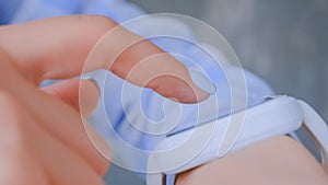 Woman hands using wearable white smart watch device - close up side view