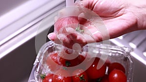 woman hands washing cherry tomatoes in kitchen sink closeup