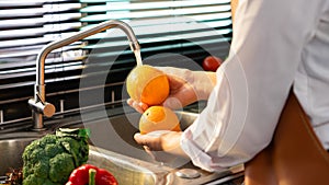 Woman hands washing Vegetables for Preparation of vegan salad on the worktop near to sink in a modern kitchen, Homemade healthy