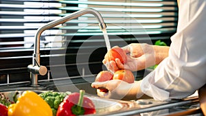 Woman hands washing Vegetables for Preparation of vegan salad on the worktop near to sink in a modern kitchen, Homemade healthy