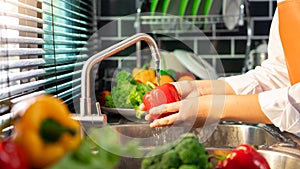 Woman hands washing Vegetables for Preparation of vegan salad on the worktop near to sink in a modern kitchen, Homemade healthy