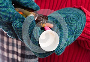 Woman hands wearing textile gloves pouring meds