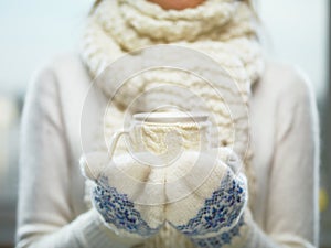 Una donna mani bianco un blu guanti possesso accogliente lavorato maglia tazza caldo cacao tè O caffè. un periodo natalizio 
