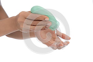 Woman hands, on White empty isolated background using hand sanitizer small squeezable green dispenser alcohol gel, coronavirus