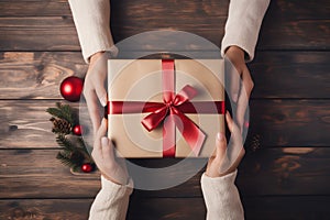 A woman hands will present a wrapped Christmas gift