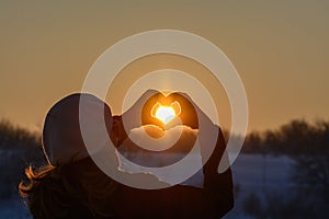 Woman hands in winter gloves. Heart symbol shaped, lifestyle and