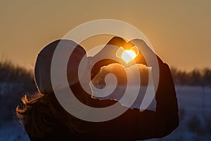 Woman hands in winter gloves. Heart symbol shaped, lifestyle and