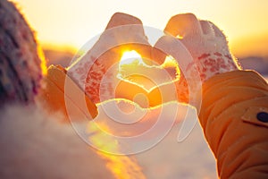 Woman hands in winter gloves Heart symbol shaped photo