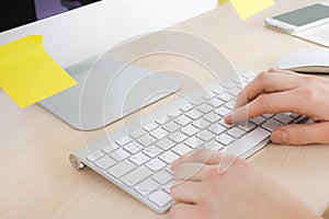 Woman hands working with computer keyboard at wooden office desk