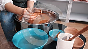 Woman hands working on pottery wheel and making pot