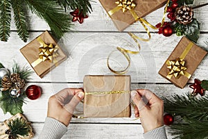 Woman hands wrapping gift box on wooden background