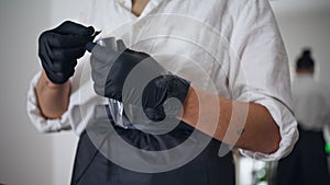 Woman hands wrapping tattoo machine at home. Girl putting disinfectant coating