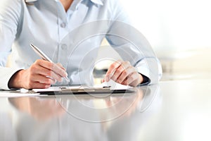 Woman hands writing on clipboard with a pen, isolated