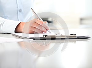 Woman hands writing on clipboard with a pen, isolated