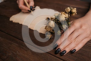 Woman hands writing someting on a vintage paper.