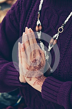 Woman hands in namaste mudra gesture  with henna drowing on hands outdoor shot