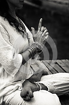 Woman hands in yoga symbolic gesture mudra bw outdoor