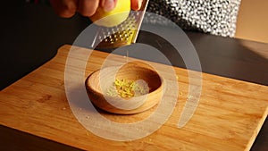 Woman hands zesting a lemon closeup