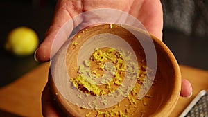 Woman hands zesting a lemon closeup