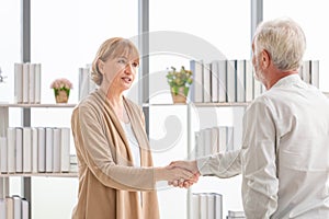 Woman handshaking greeting senior man client, Health visitor, and a senior man during a home visit