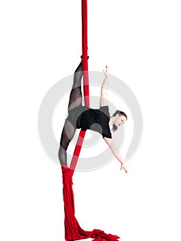Woman hanging in aerial silks, isolated on white