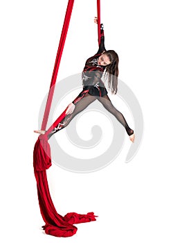 Woman hanging in aerial silks, isolated on white