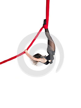 Woman hanging in aerial silks, isolated on white