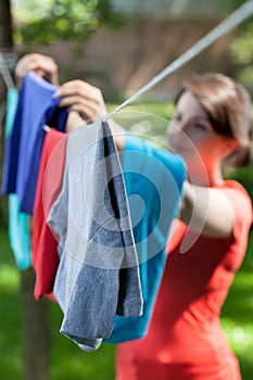 Woman hanging clothes on laundry line in garden