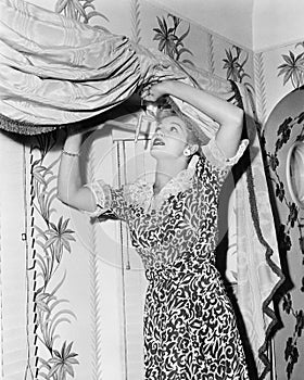 Woman hanging a valance