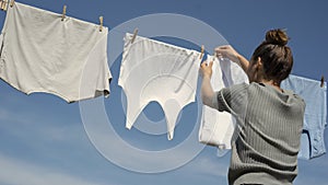 Woman hangs laundry on clothesline