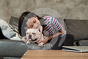 Woman is happily fun playing and teasing dog French Bulldog
