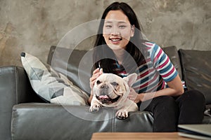 Woman is happily fun playing and teasing dog French Bulldog