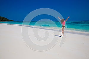 Woman. Happiness bliss freedom beach concept. Enjoyment. Beautiful model jumping on exoptic beach with white sand and blue water.