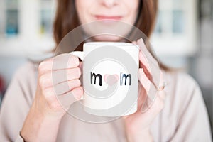 Woman happy about being a mother, holding a mother\'s day cup