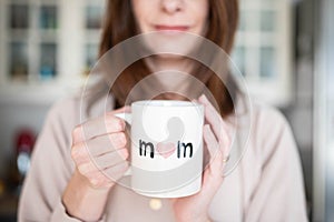 Woman happy about being a mother, holding a mother\'s day cup