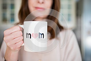 Woman happy about being a mother, holding a mother\'s day cup