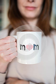 Woman happy about being a mother, holding a mother\'s day cup