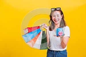 Woman happy hold colorful shopping bags and Piggybank Saving money