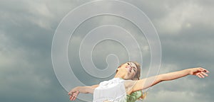 Woman happy joyful with arms up against sky