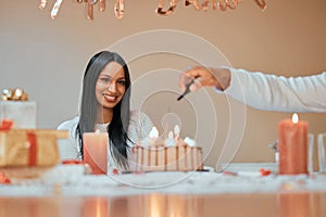 Woman, happy and lighting candles on cake for birthday, celebration and pride in apartment for life event. Female person