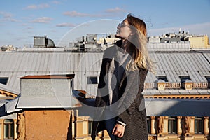 Woman is happy on the roof of Saint Petersburg, Russia. Cityscape view