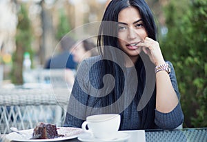 Woman happy & sexy. Closeup portrait beautiful smiling flirting girl student hand on lips looking at you camera coffee shop